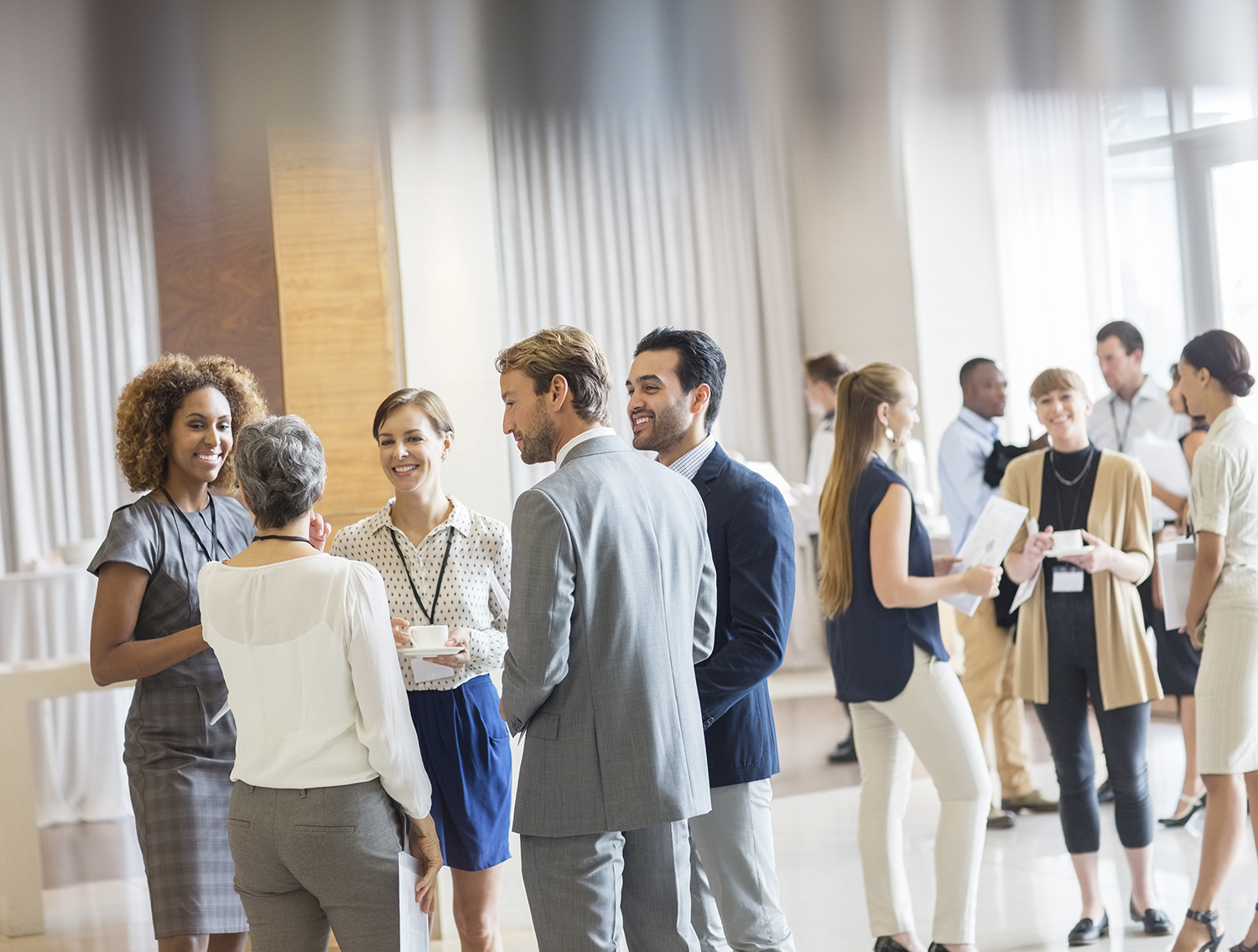 Group of business people standing in hall, smiling and talking together