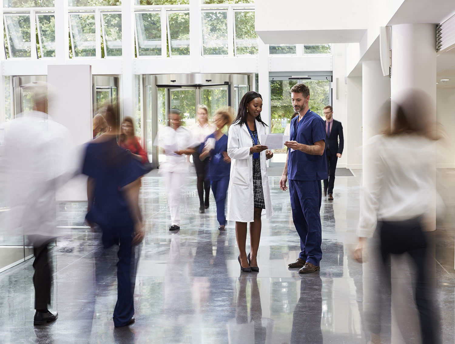 Staff In Busy Lobby Area Of Modern Hospital