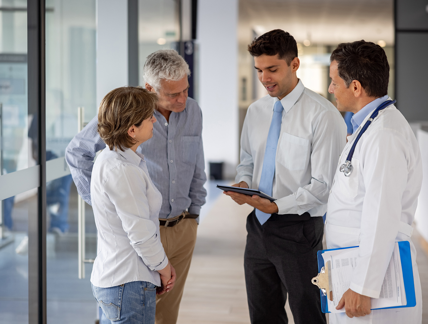 Latin American patients talking to the hospital manager and a doctor about their health insurance coverage