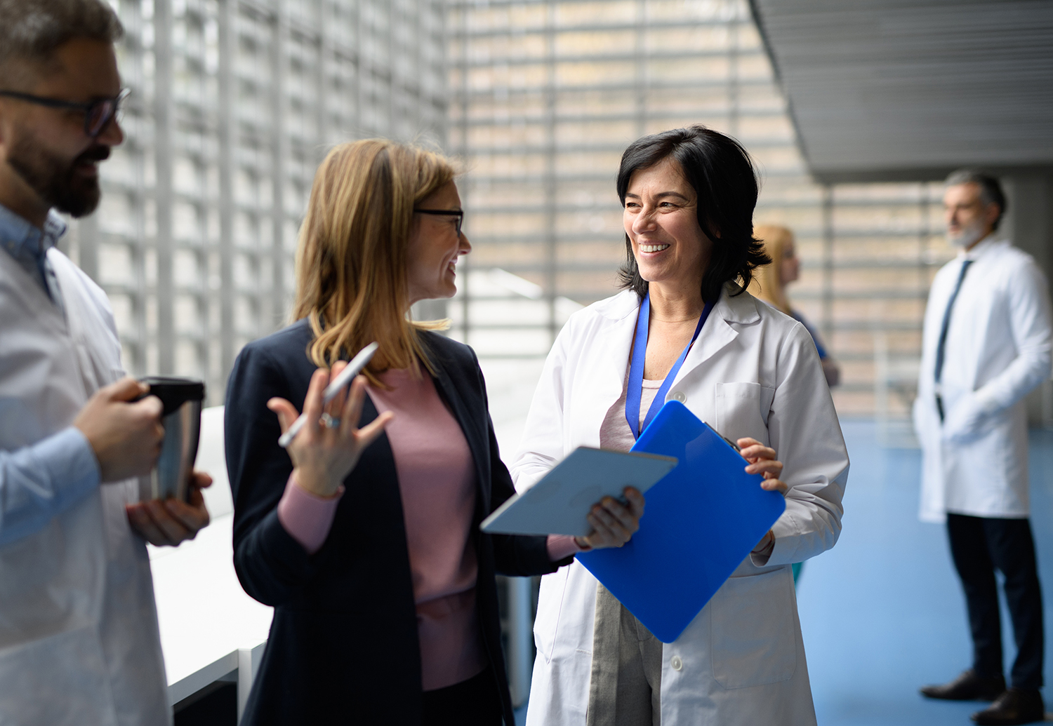 Doctors talking to pharmaceutical sales representative, presenting new pharmaceutical product. Hospital director, manager talking with doctors team.