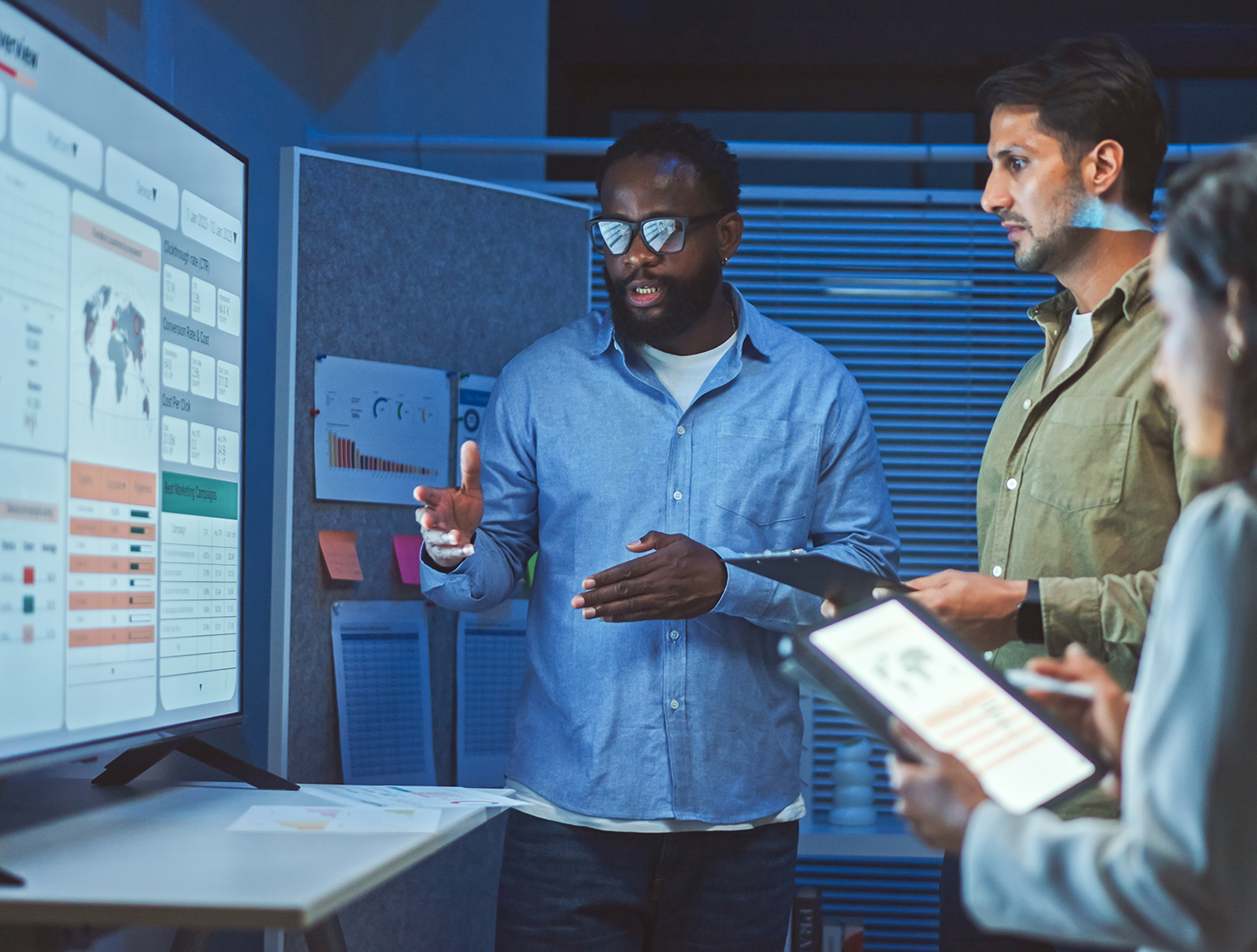 A team of multiethnic developers is meeting to review the data analysis of marketing from social media platforms.